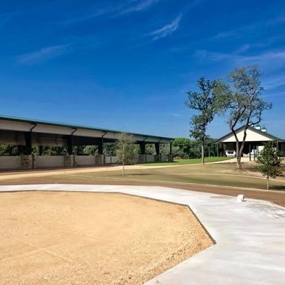 Concrete walkway with the covered arena and barn behind
