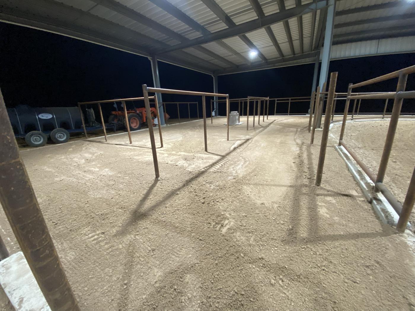 Pipe pens alongside a finished arena at night